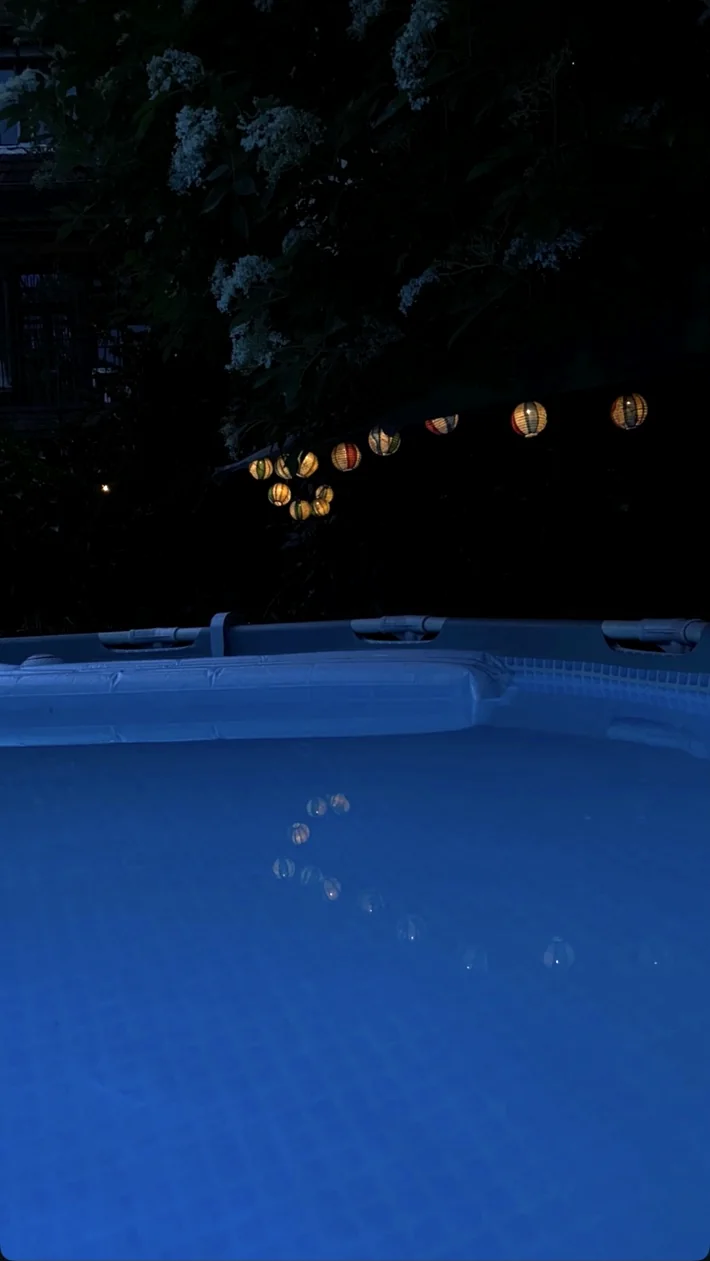Hermanns Garden's illuminated blue pool and garden lanterns at night